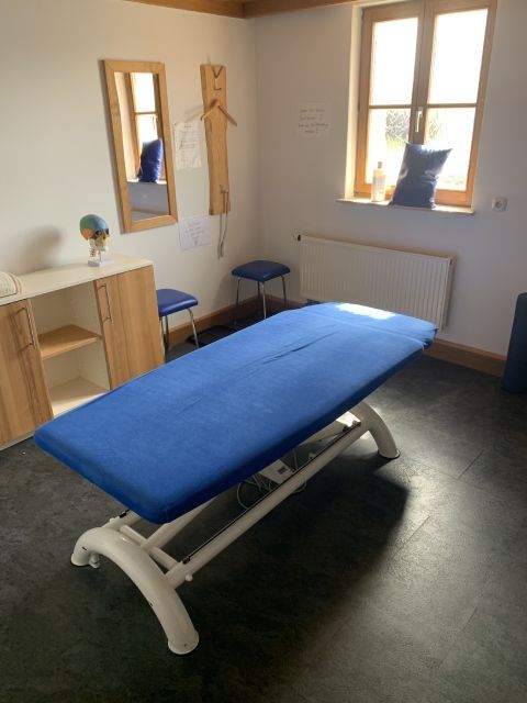 CompliSanus Behandlungszimmer mit blauer Liege