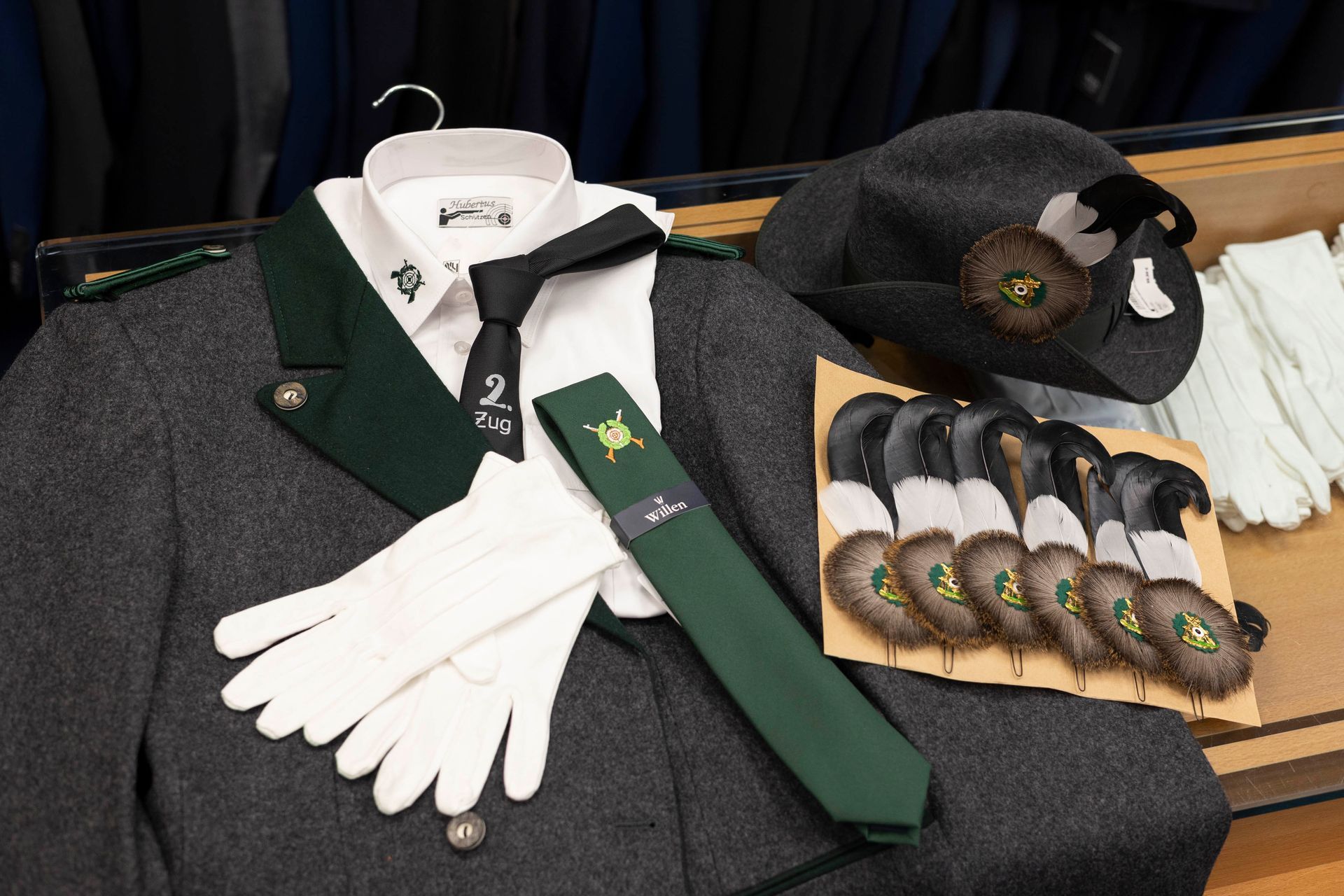Ein Herrenanzug mit grüner Krawatte und weißen Handschuhen