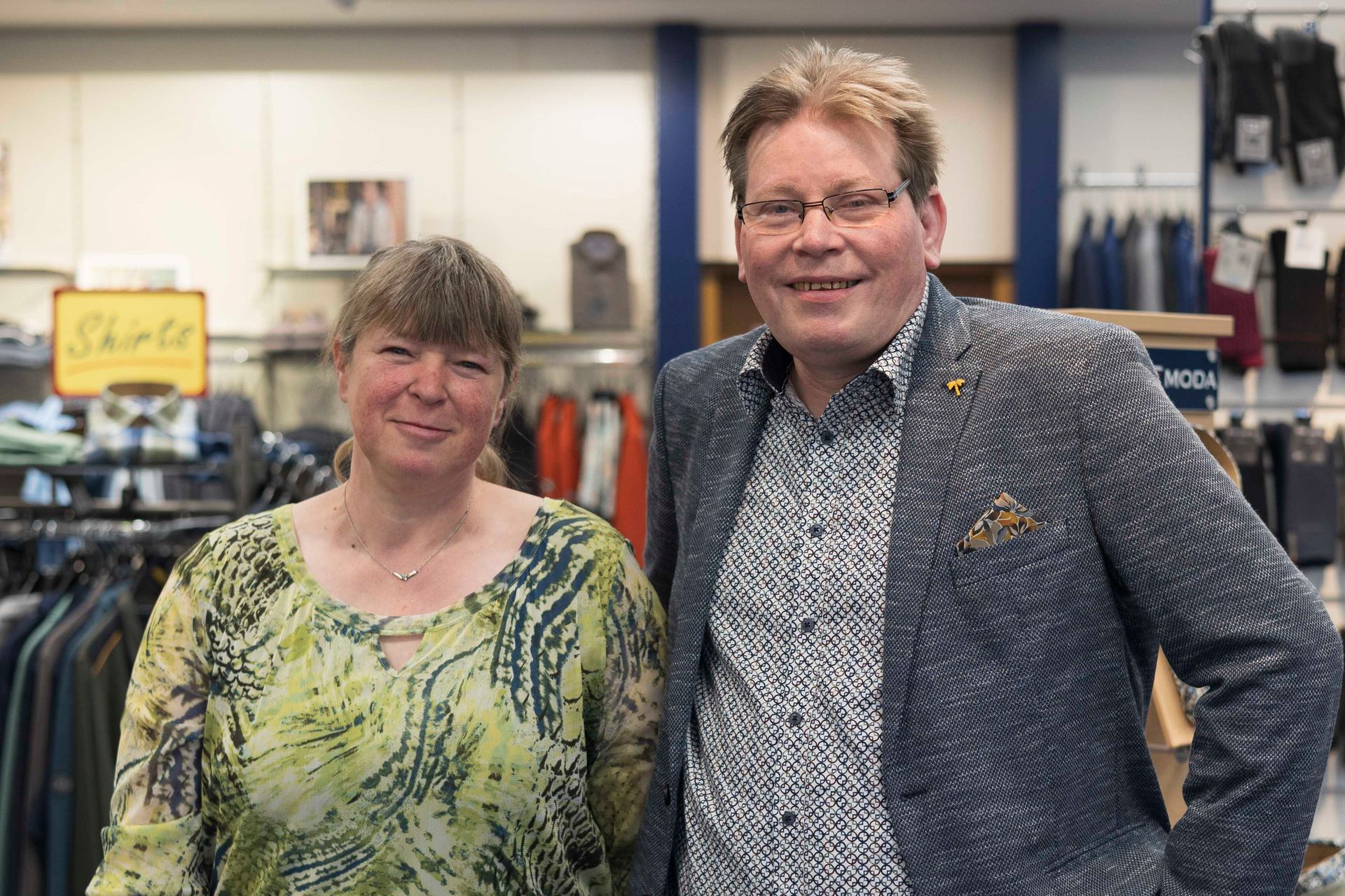 Ein Mann und eine Frau posieren in einem Bekleidungsgeschäft für ein Foto.