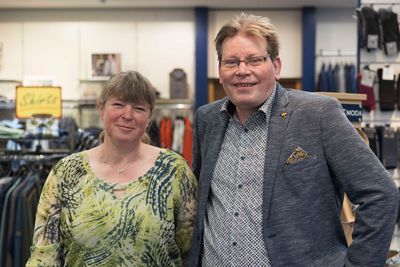 Ein Mann und eine Frau posieren in einem Bekleidungsgeschäft für ein Foto.