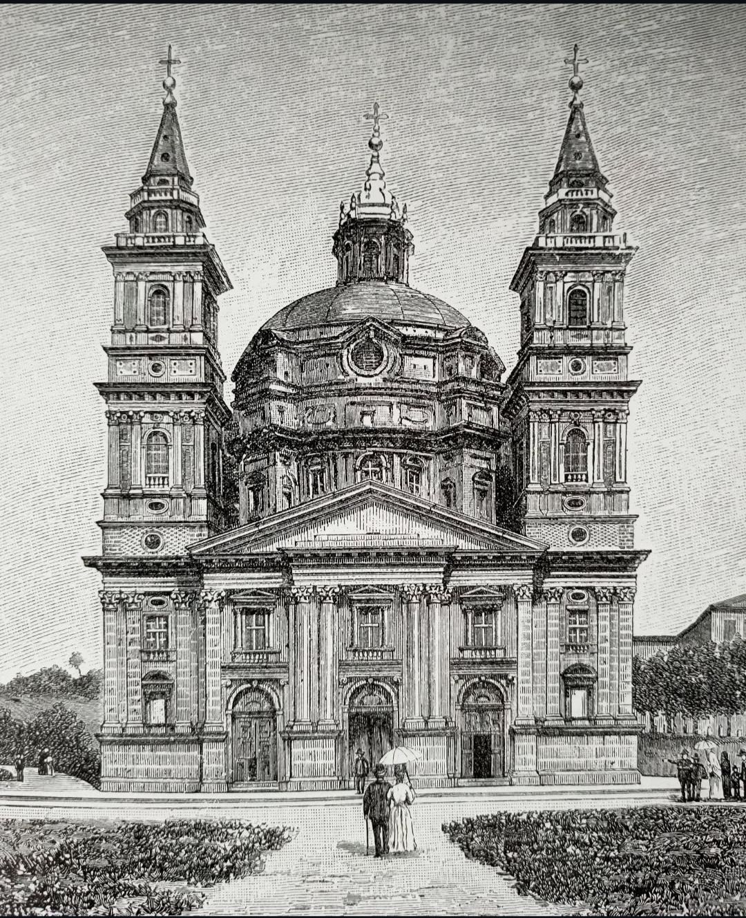 Vista frontal de una gran catedral con techo abovedado, torres gemelas y figuras al frente.