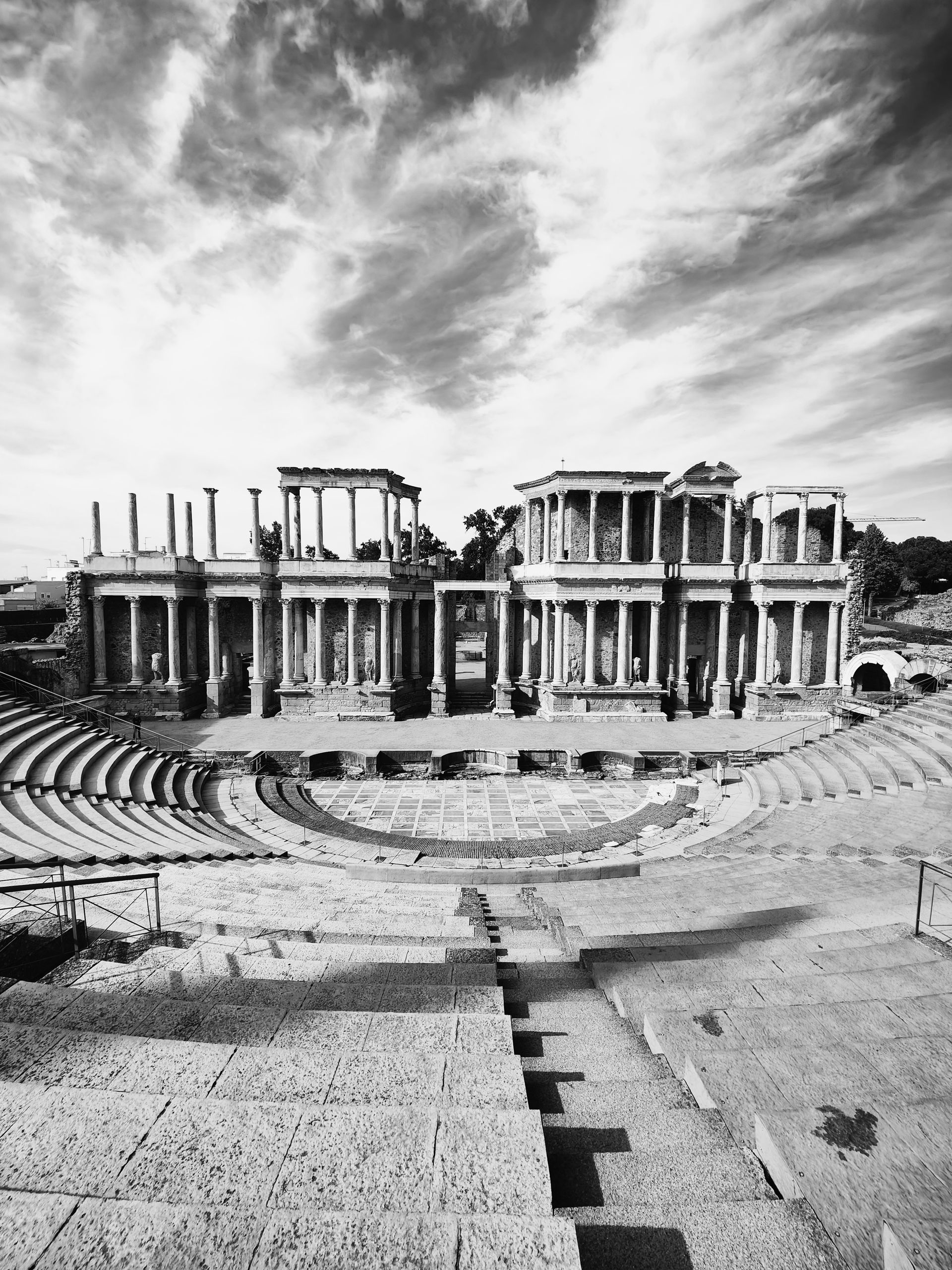 Fotografía en blanco y negro del Teatro Romano de Mérida, España, con arquitectura de piedra.