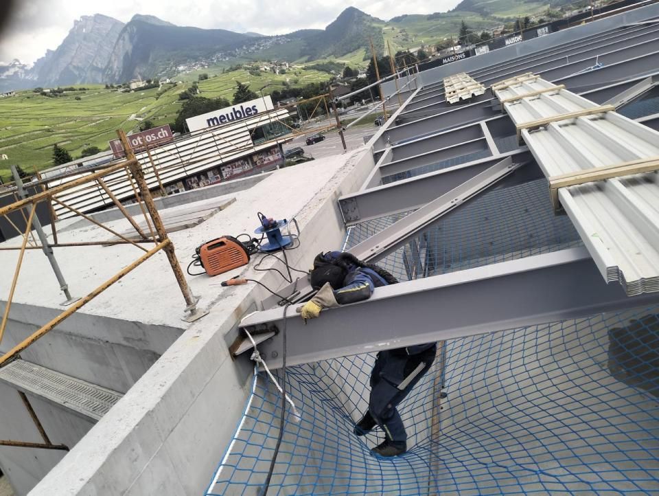 Un homme travaille sur le toit d'un immeuble.