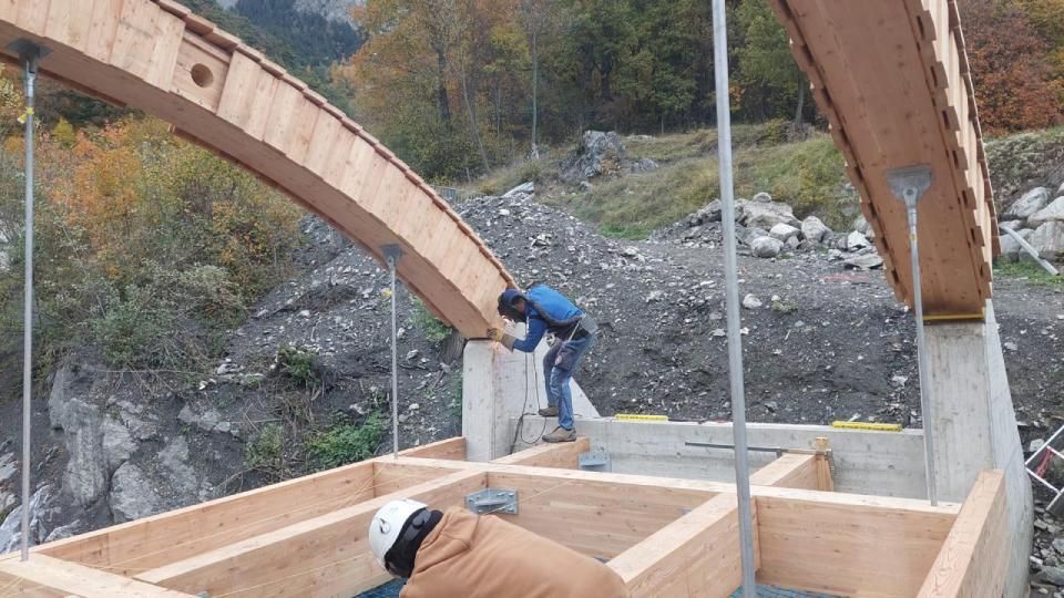 Un homme travaille sur un pont en bois en construction.