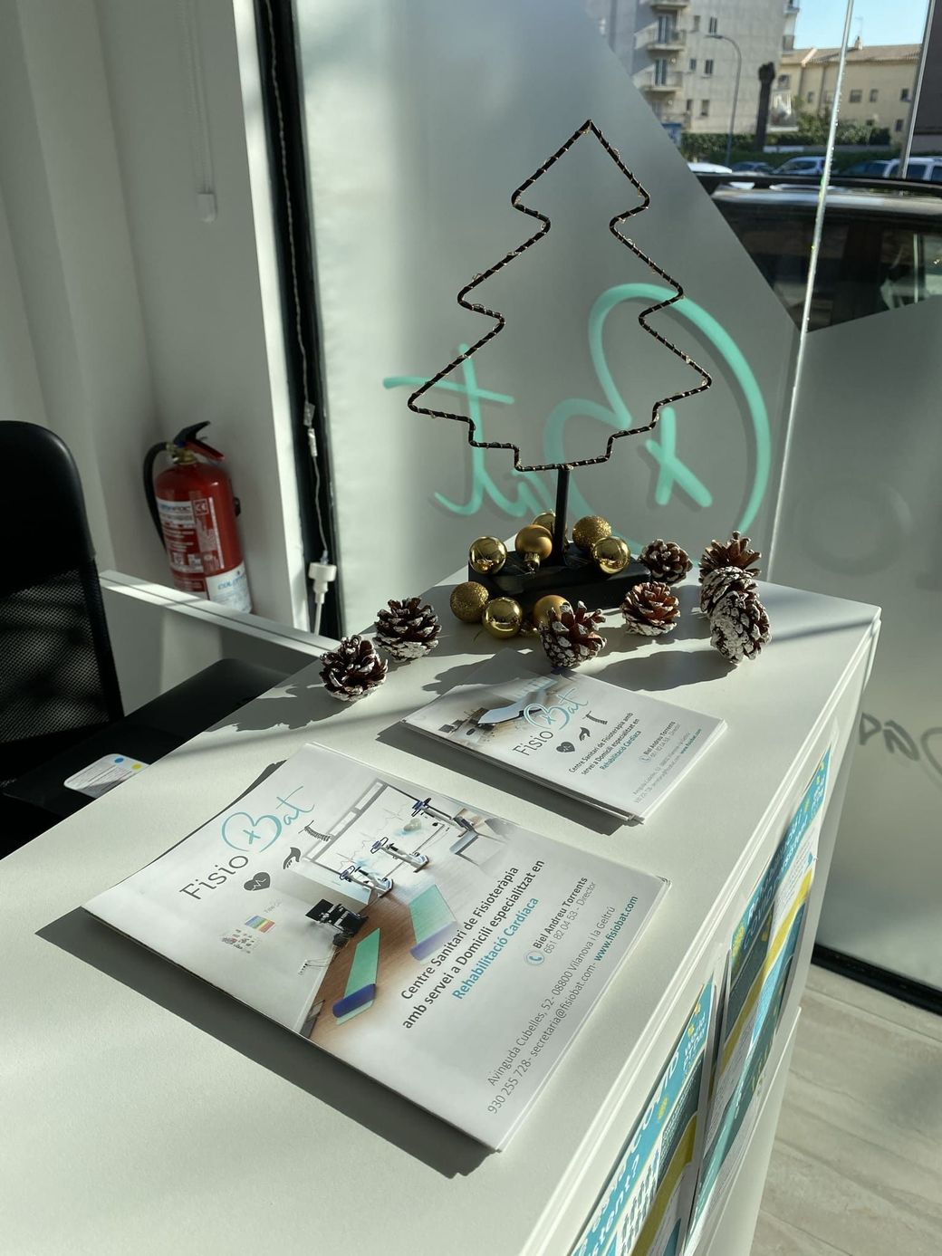 Mostrador de recepción con decoración de árbol de navidad y papeles.