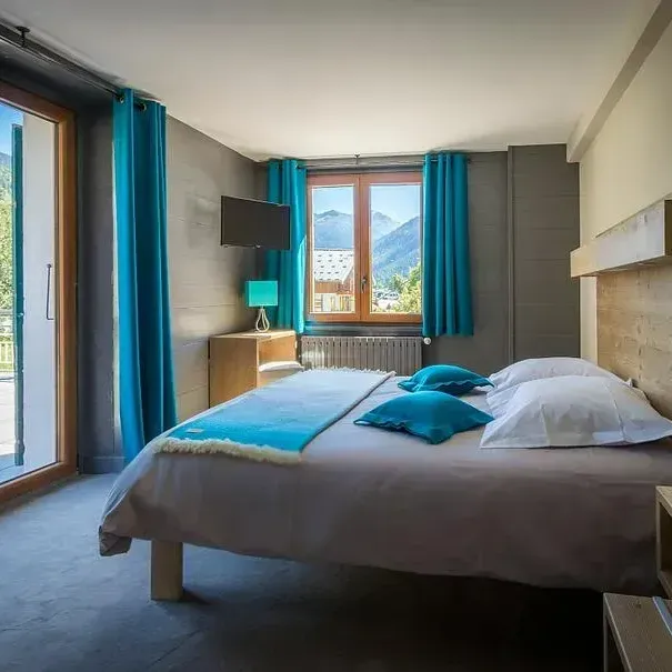 Chambre décorée de bleu et de gris avec vue sur la montagne