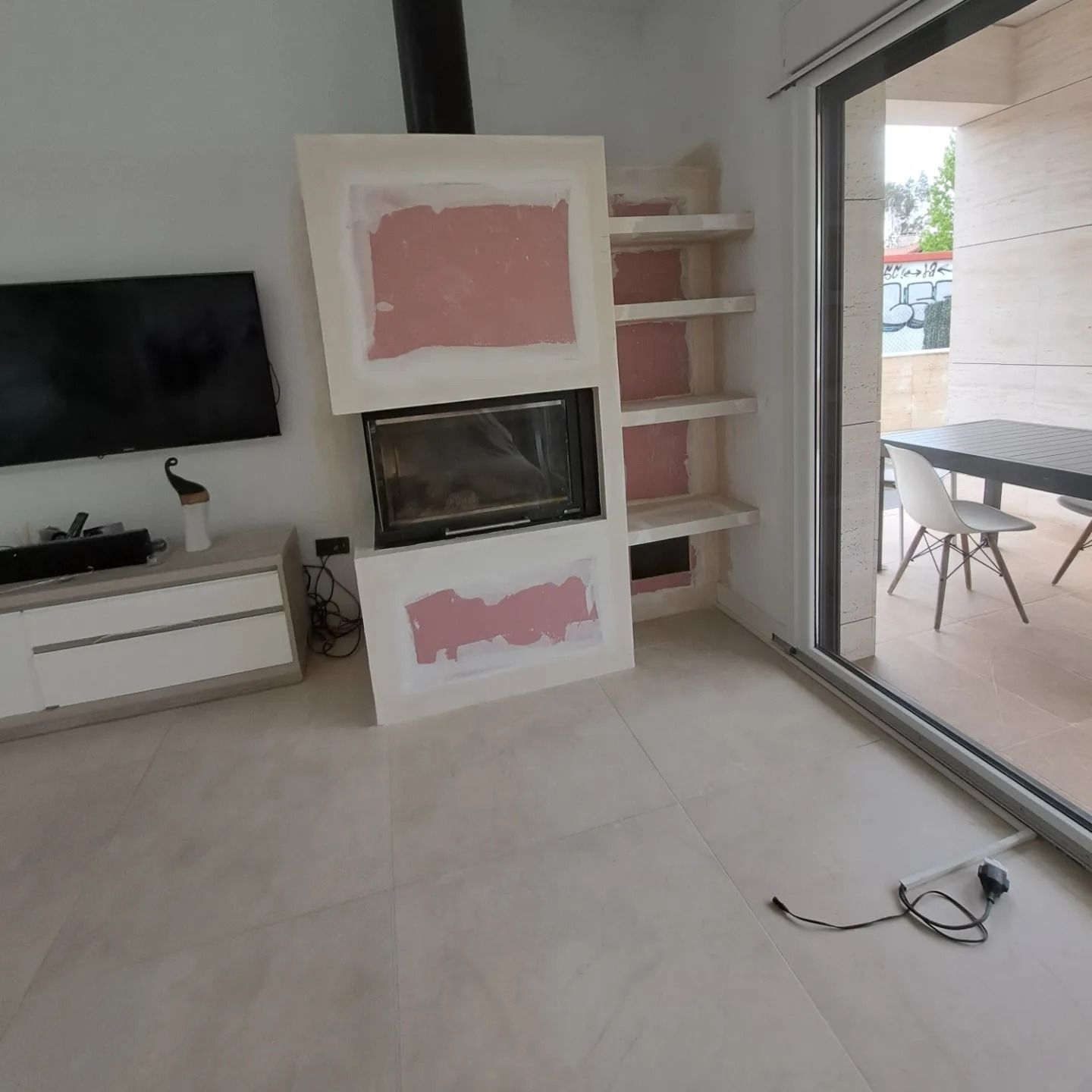 Una sala de estar con chimenea y TV de pantalla plana.