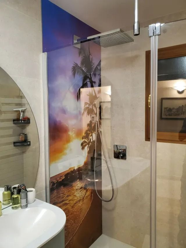 Douche moderne avec paroi en verre, fresque tropicale et lavabo visible
