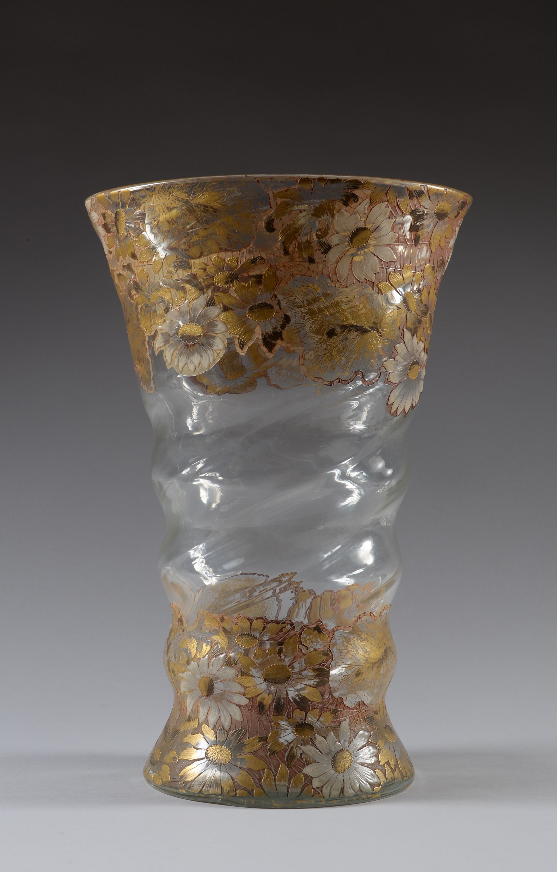 Emile GALLE (1846-1904)
Cristallerie « aux marguerites »
Exceptionnel vase en en cristal incolore, à corps en spirale se terminant par une ouverture évasée. Décor gravé et émaillé d’émaux polychromes et or sur la base et le col de marguerites. Signé « Gallé » à la base.
Vers 1890-1894.