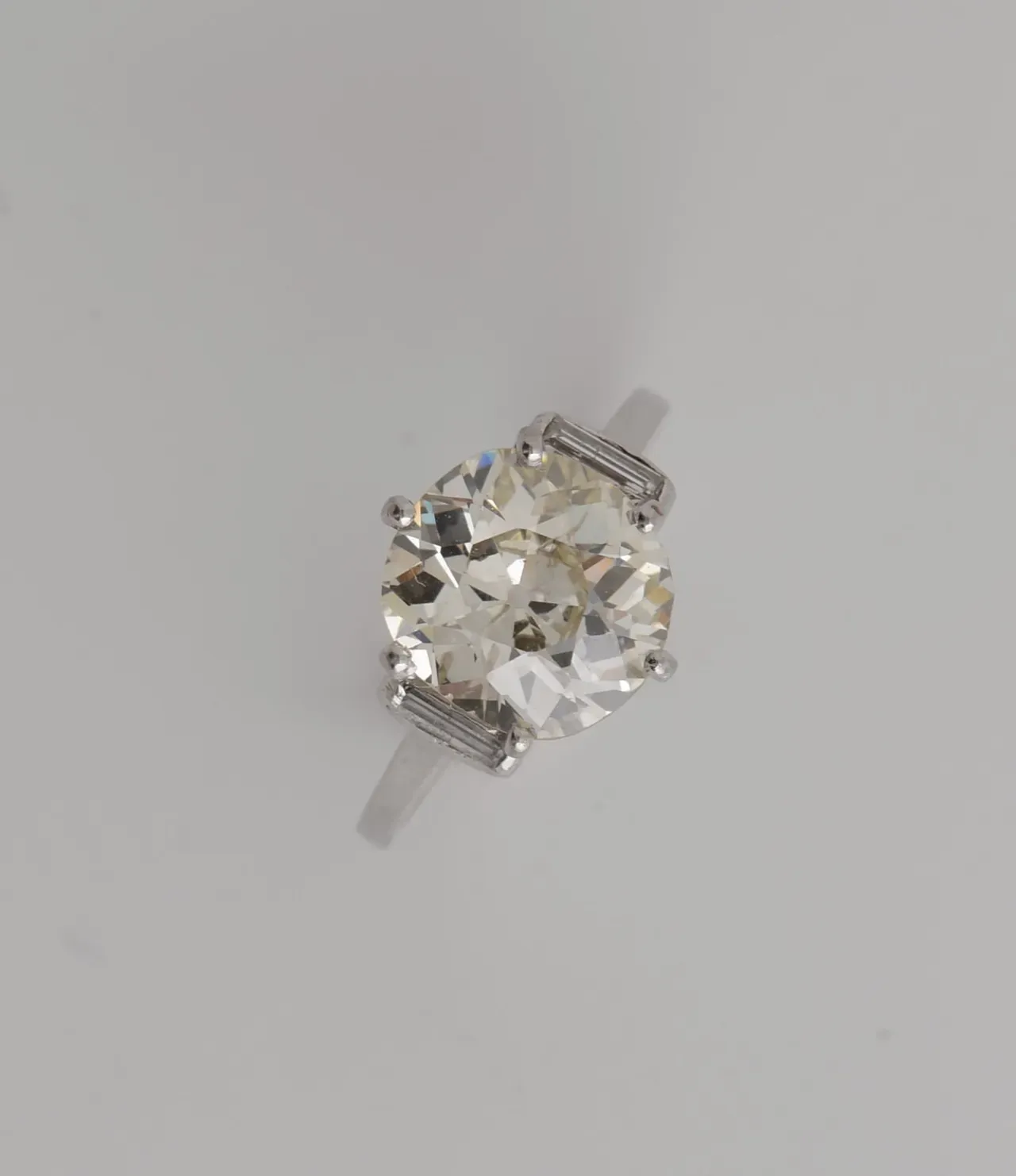 Bague en platine ornée d’un diamant solitaire de taille ancienne de 3.80 ct, pureté SI, couleur L/M, épaulé de deux diamants baguettes. Poids 4.4 g.