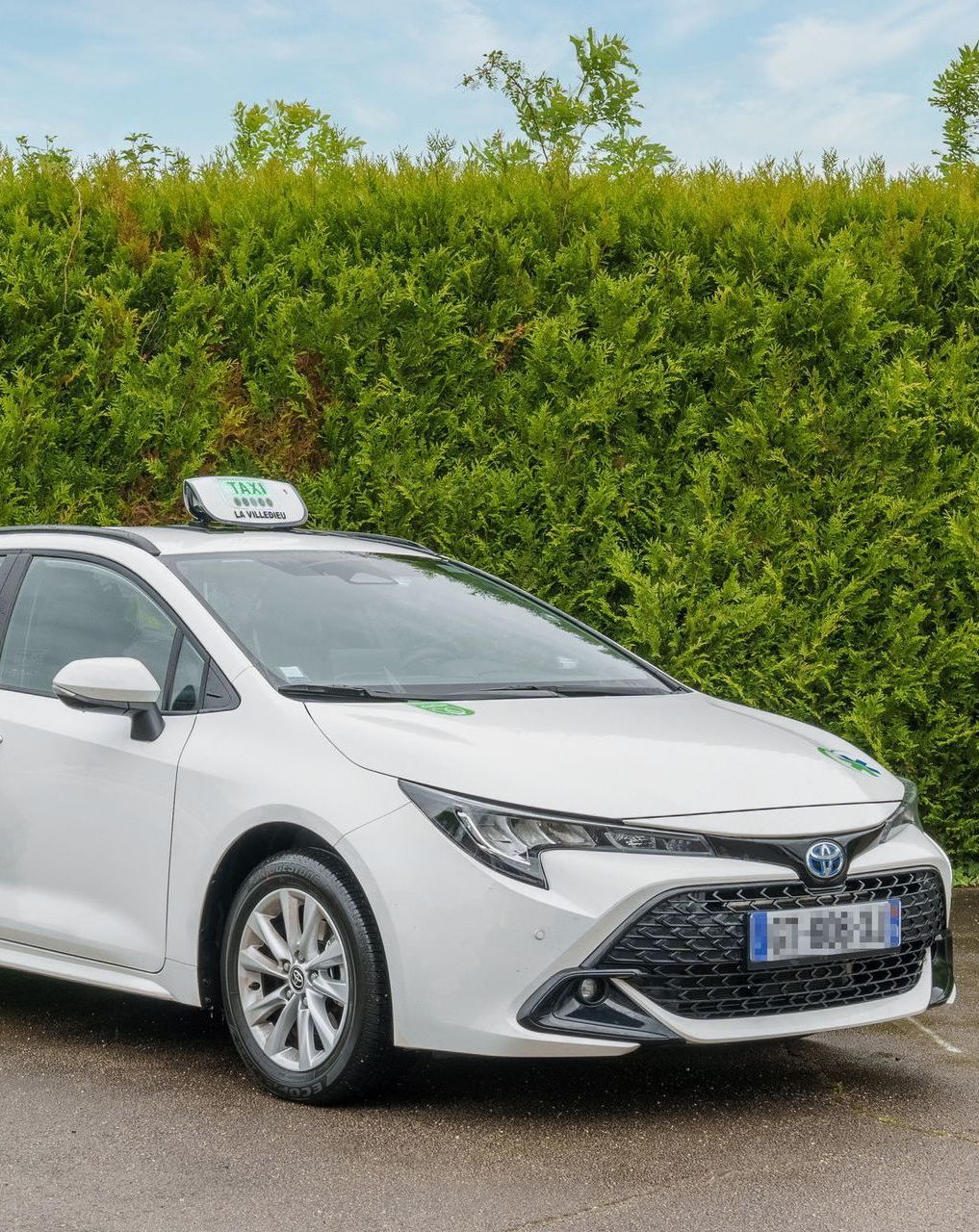 Un taxi médical devant une haie