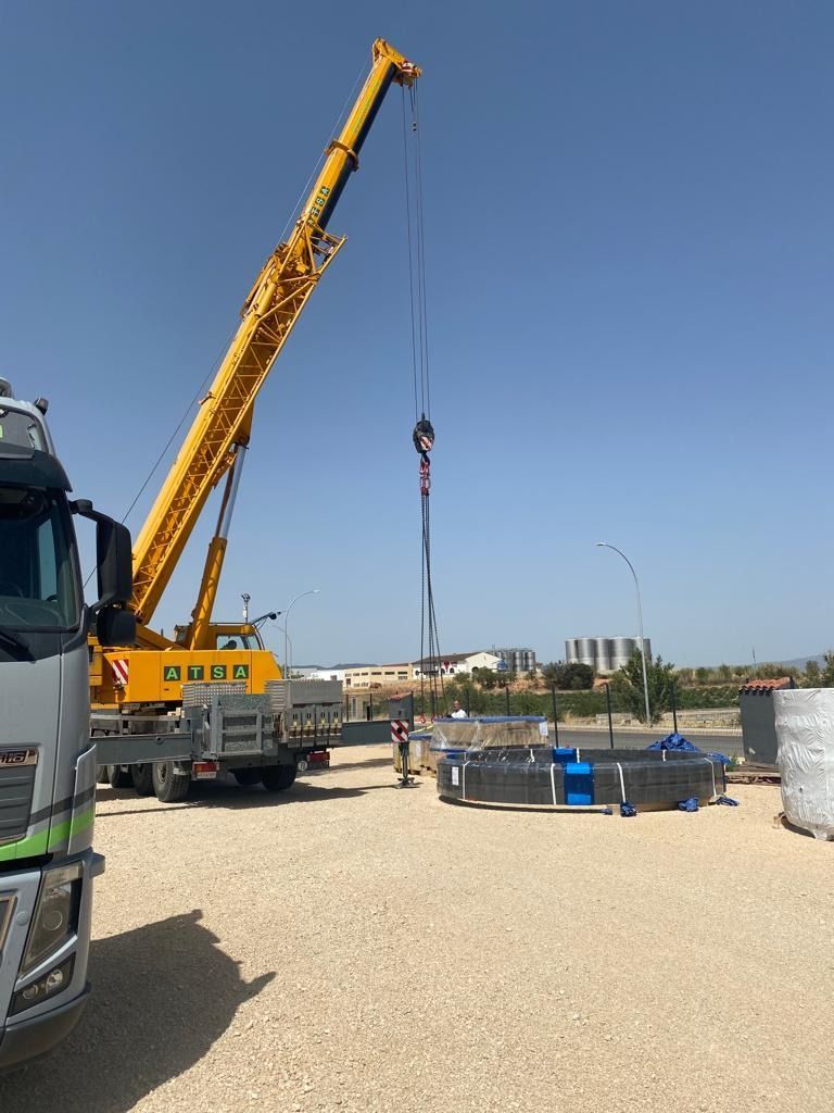 Se está utilizando una gran grúa amarilla para levantar un objeto grande.