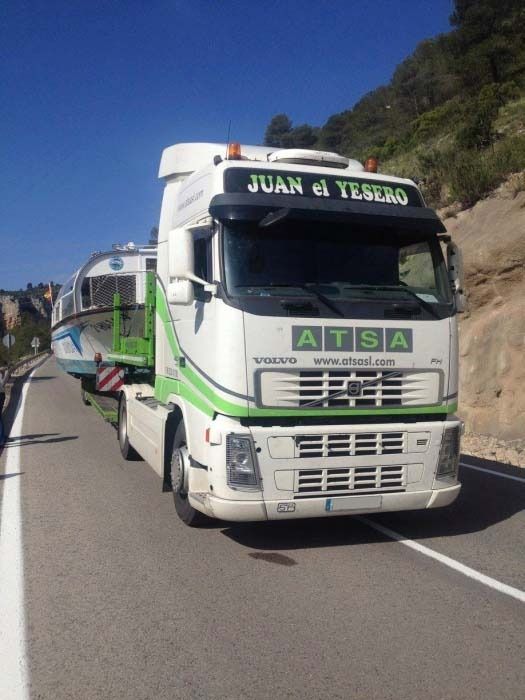Un camión ATSA blanco y verde circula por una carretera.