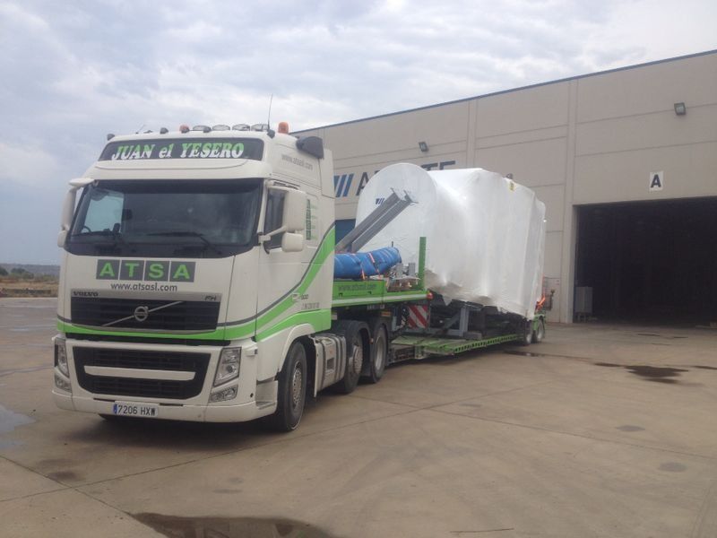 Un camión blanco y verde está estacionado frente a un edificio.