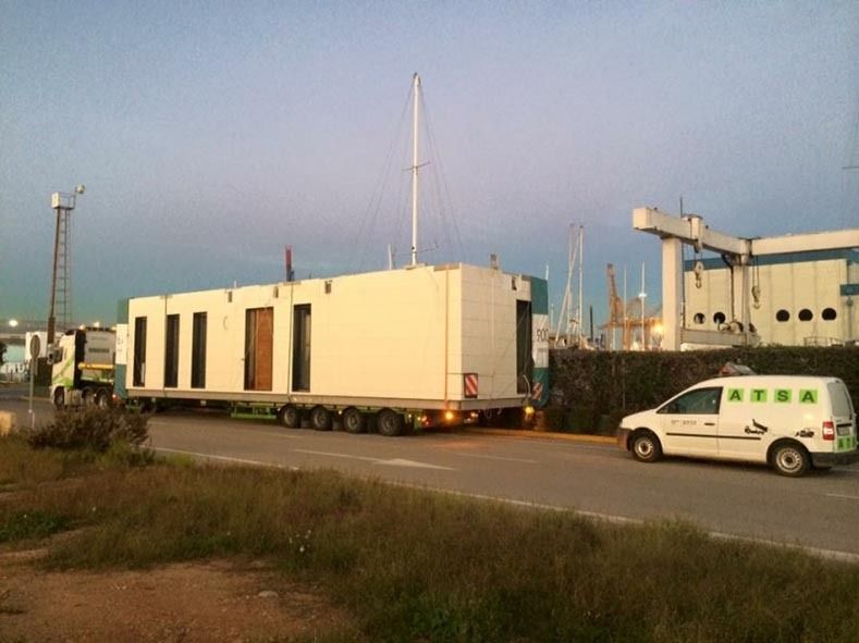 Una camioneta blanca está estacionada al costado de la carretera al lado de un gran remolque blanco.