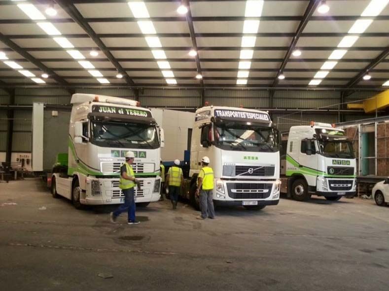 Un grupo de camiones están estacionados en un almacén.