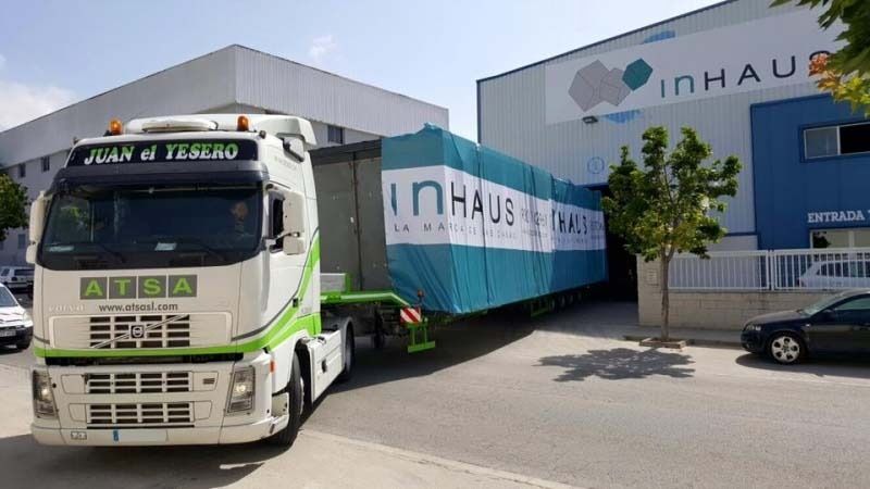 Un camión grande está estacionado frente a un edificio que dice inhaus