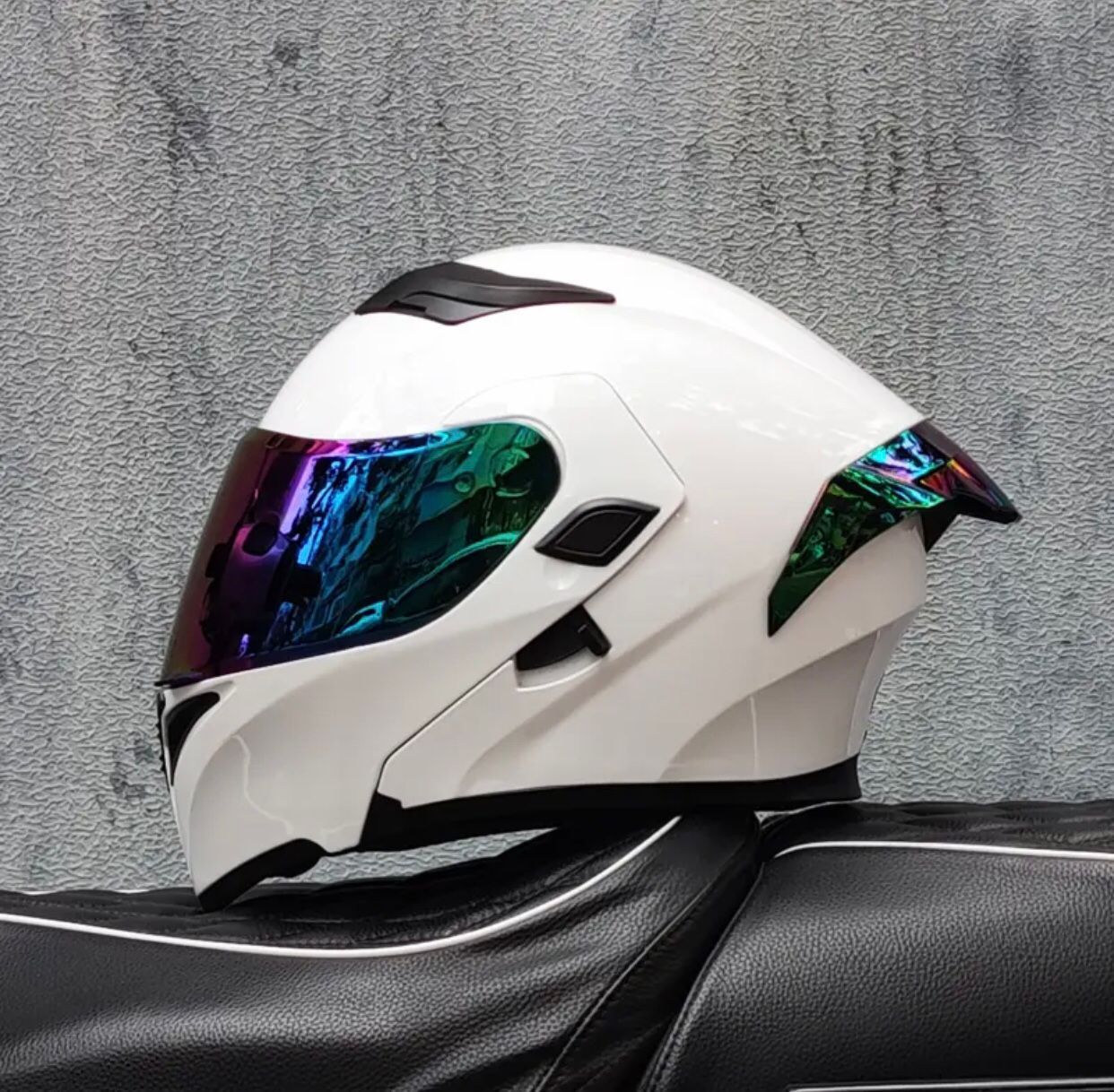Casco de motocicleta de color blanco con visera reflectante, apoyado sobre el asiento de una motocicleta.