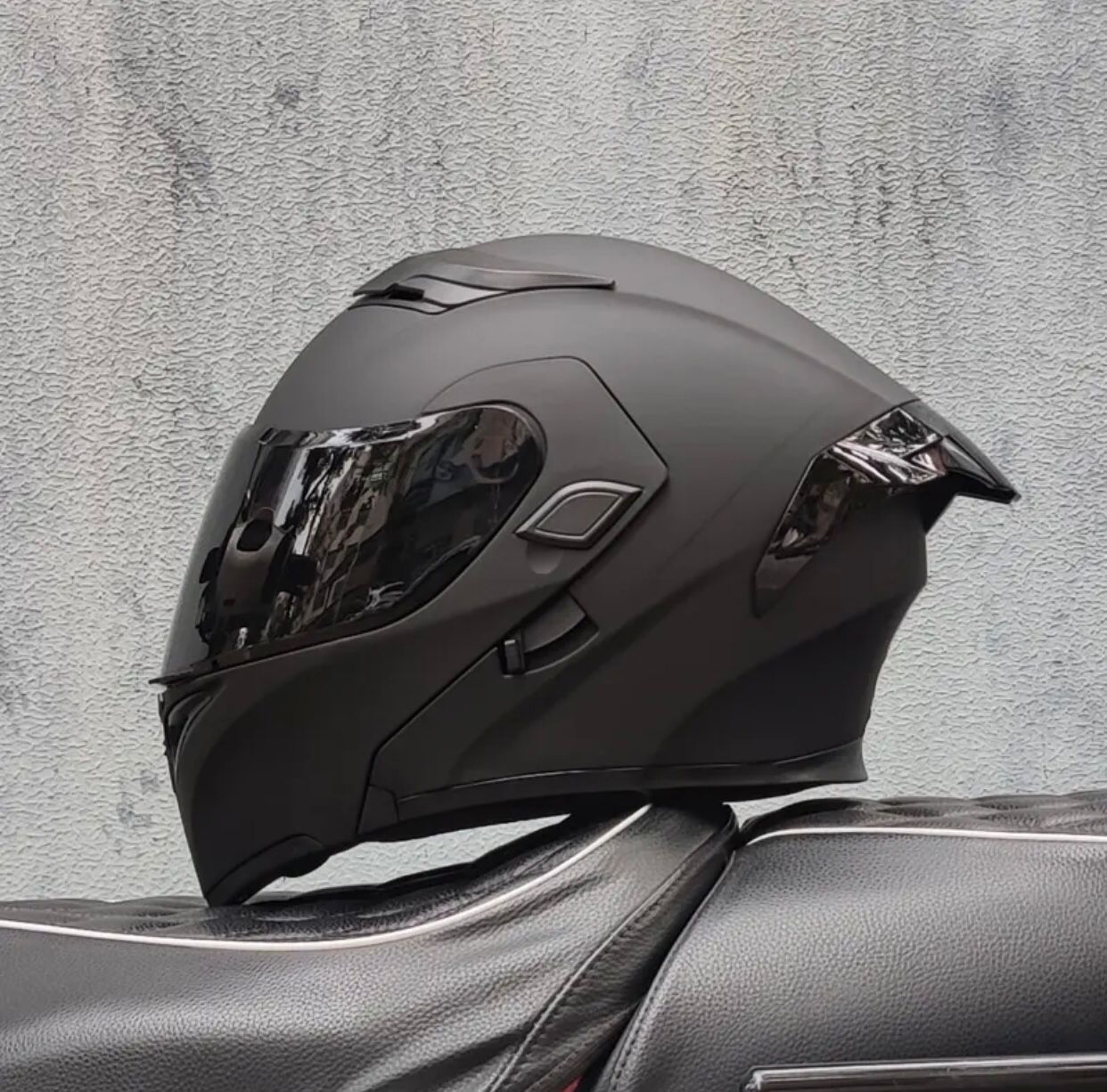 Casco de motocicleta negro mate con visera tintada.
