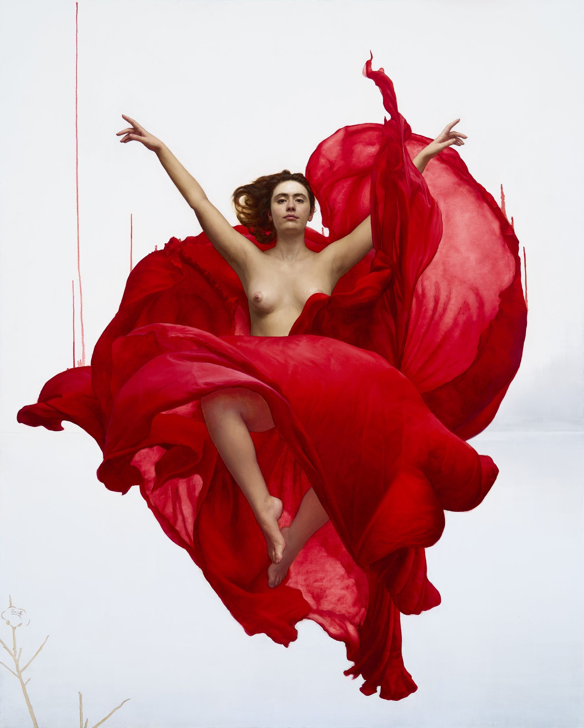 Mujer vestida con una tela roja suelta, con los brazos levantados, en el aire, sobre un fondo nevado.