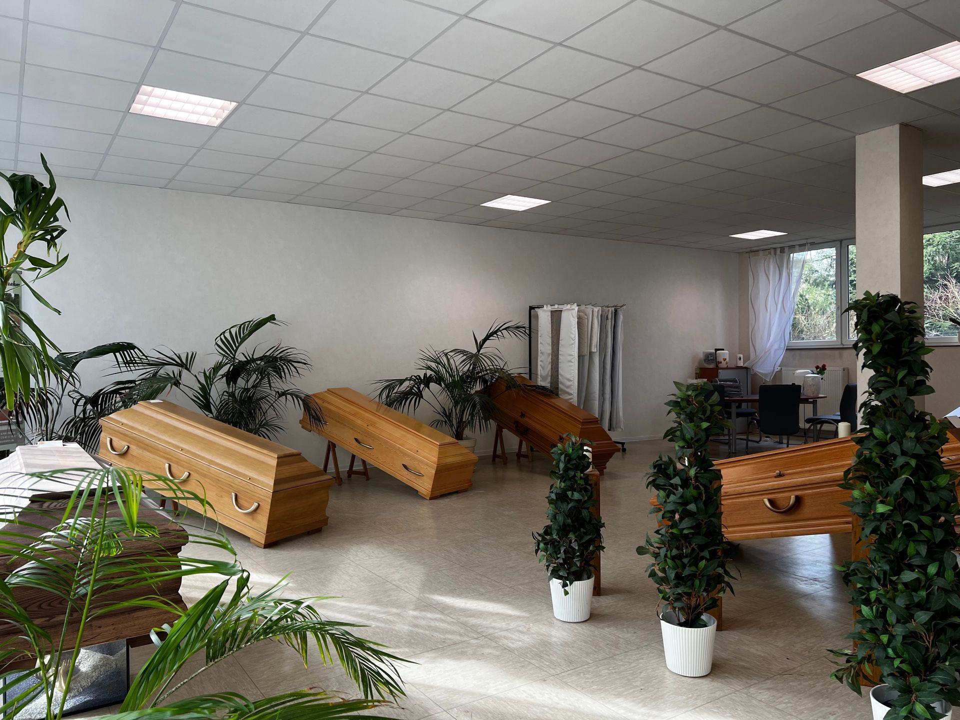 Ein Raum voller Särge und Topfpflanzen. Foto von den Bestattungen Jeup