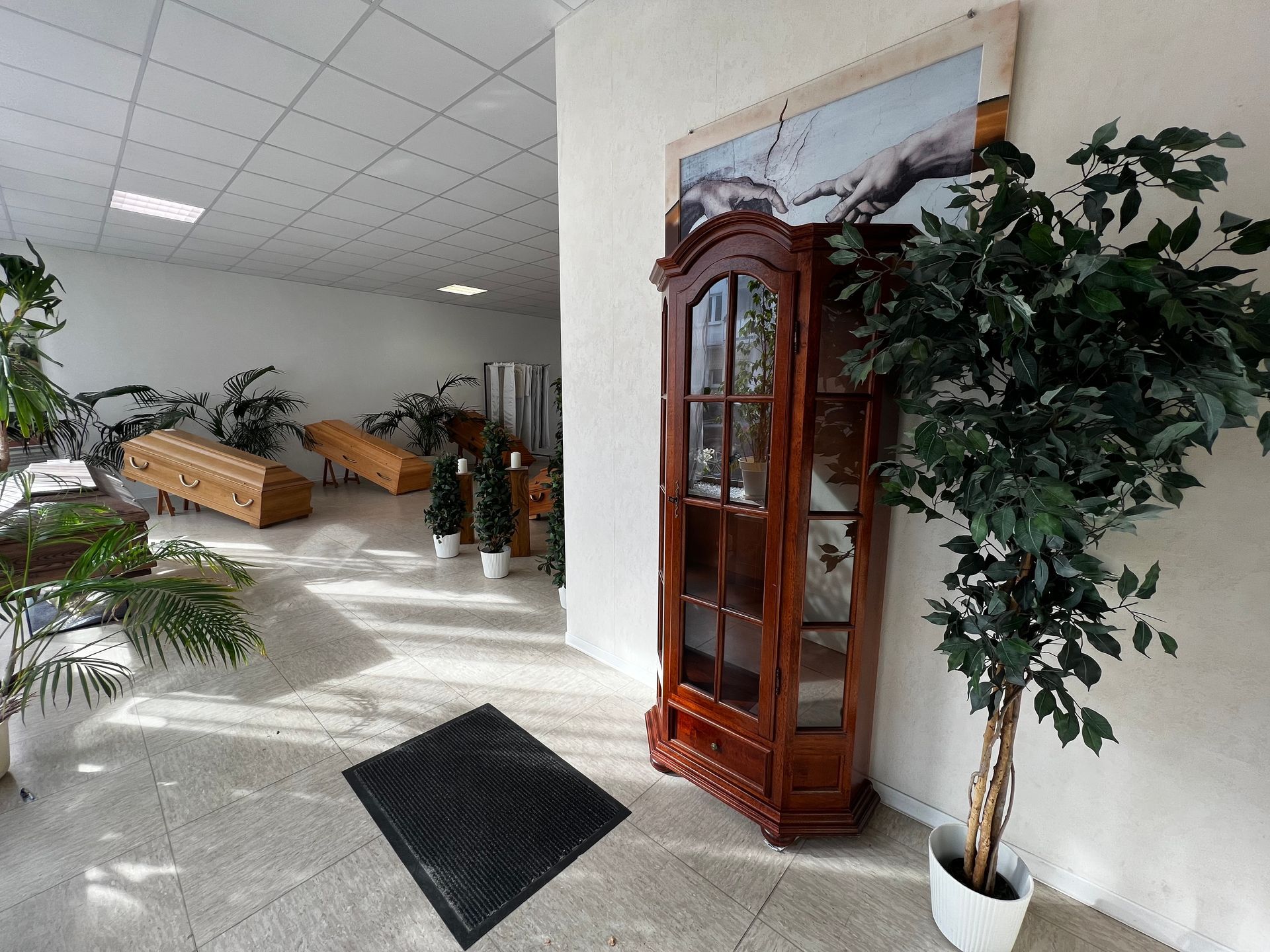 Ein Raum mit einer Uhr und einer Pflanze darin. Foto von den Bestattungen Jeup