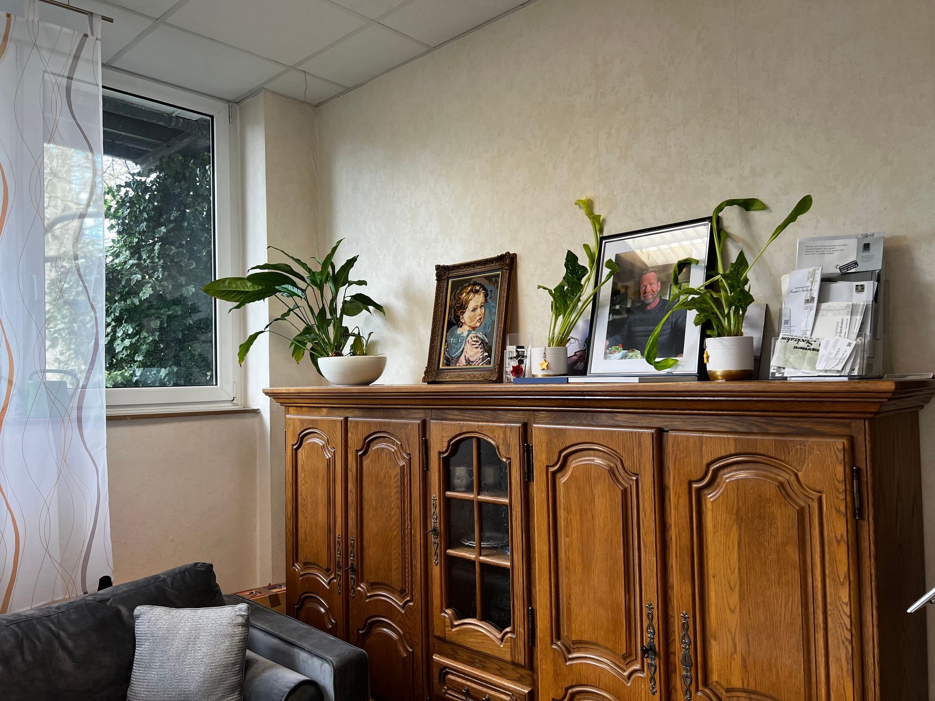 Ein Raum mit einer Couch und einem Holzschrank. Foto von den Bestattungen Jeup