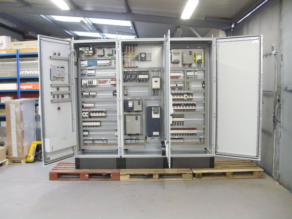 Deux grandes armoires électriques aux portes battantes ouvertes.