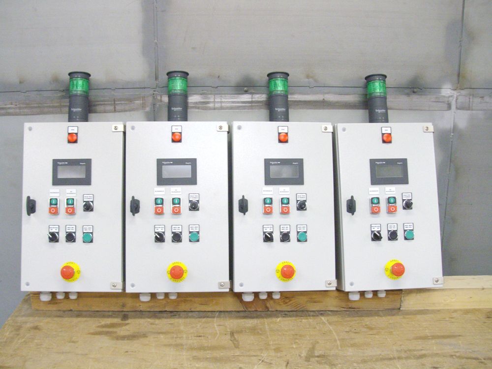 Quatres boitiers électriques accrochés au mur.