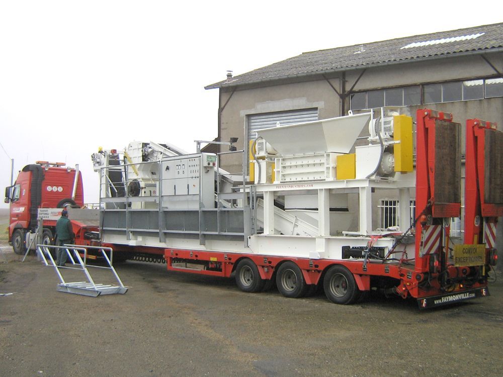 Un grand poids lourd  rouge de transport de machinerie.