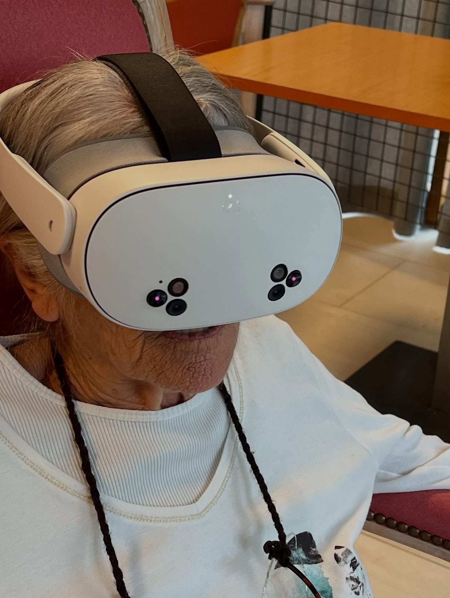 Une personne âgée portant un casque de réalité virtuelle.
