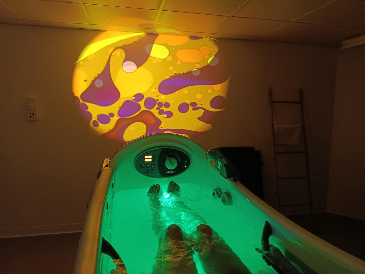 Projection lumineuse abstraite et colorée au-dessus d'un bassin de balnéothérapie.