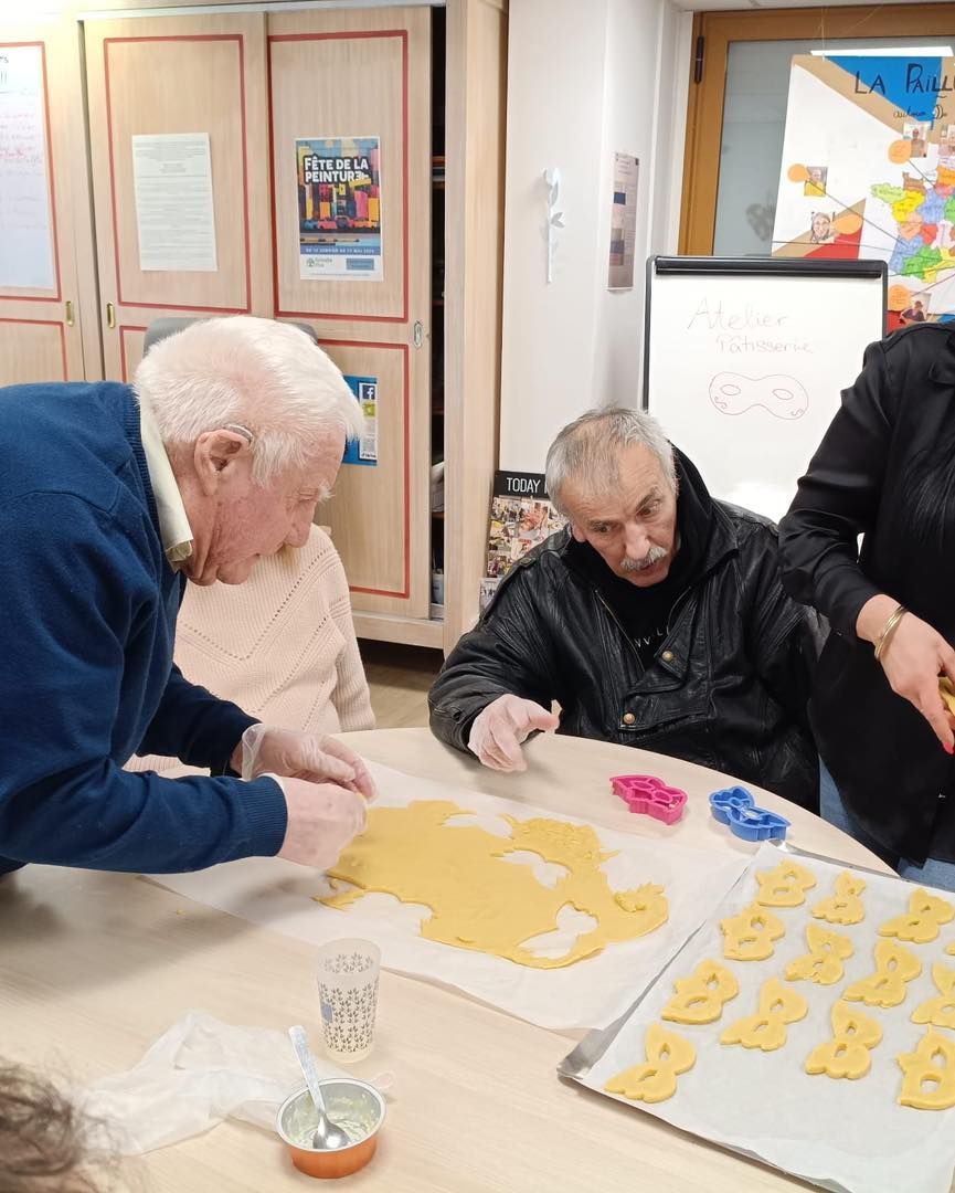 Des personnes travaillent ensemble autour d'une table pour préparer des biscuits.