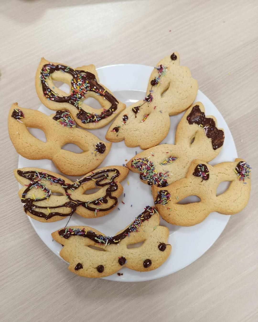 Assiette de biscuits décorés en forme de papillon assortis sur une table.