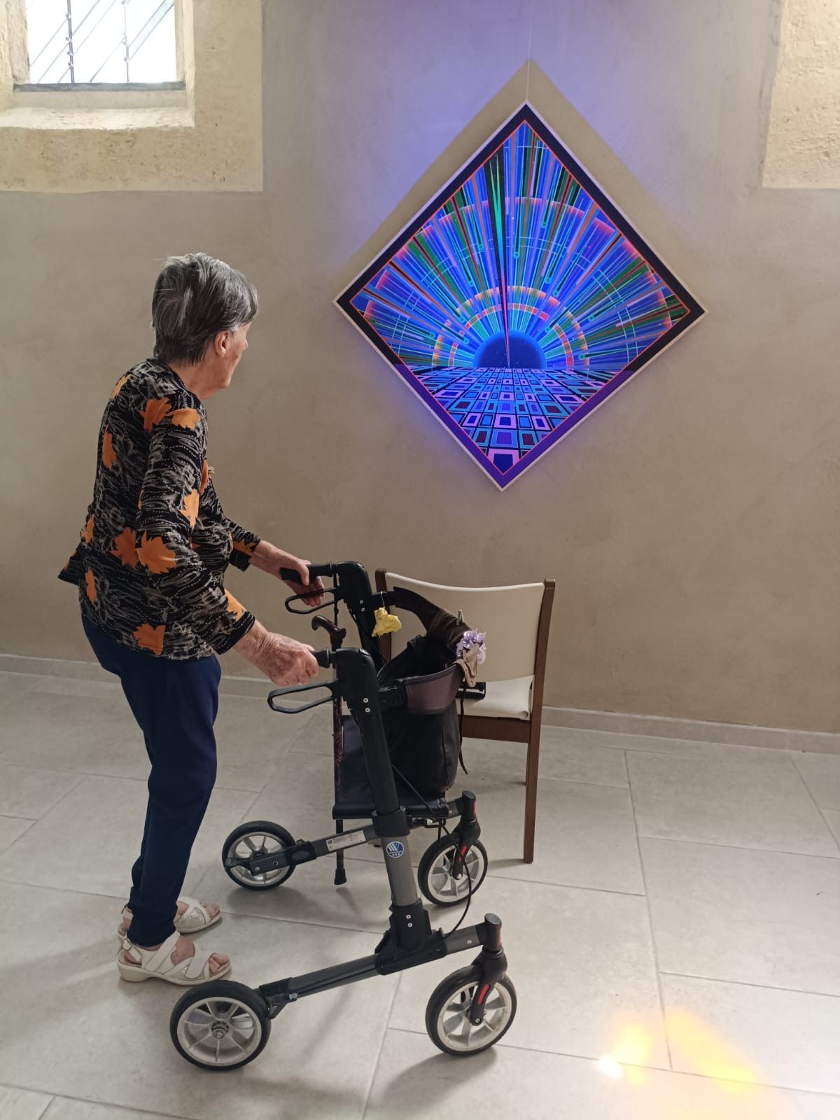 Une personne âgée admire une pièce d'art murale.