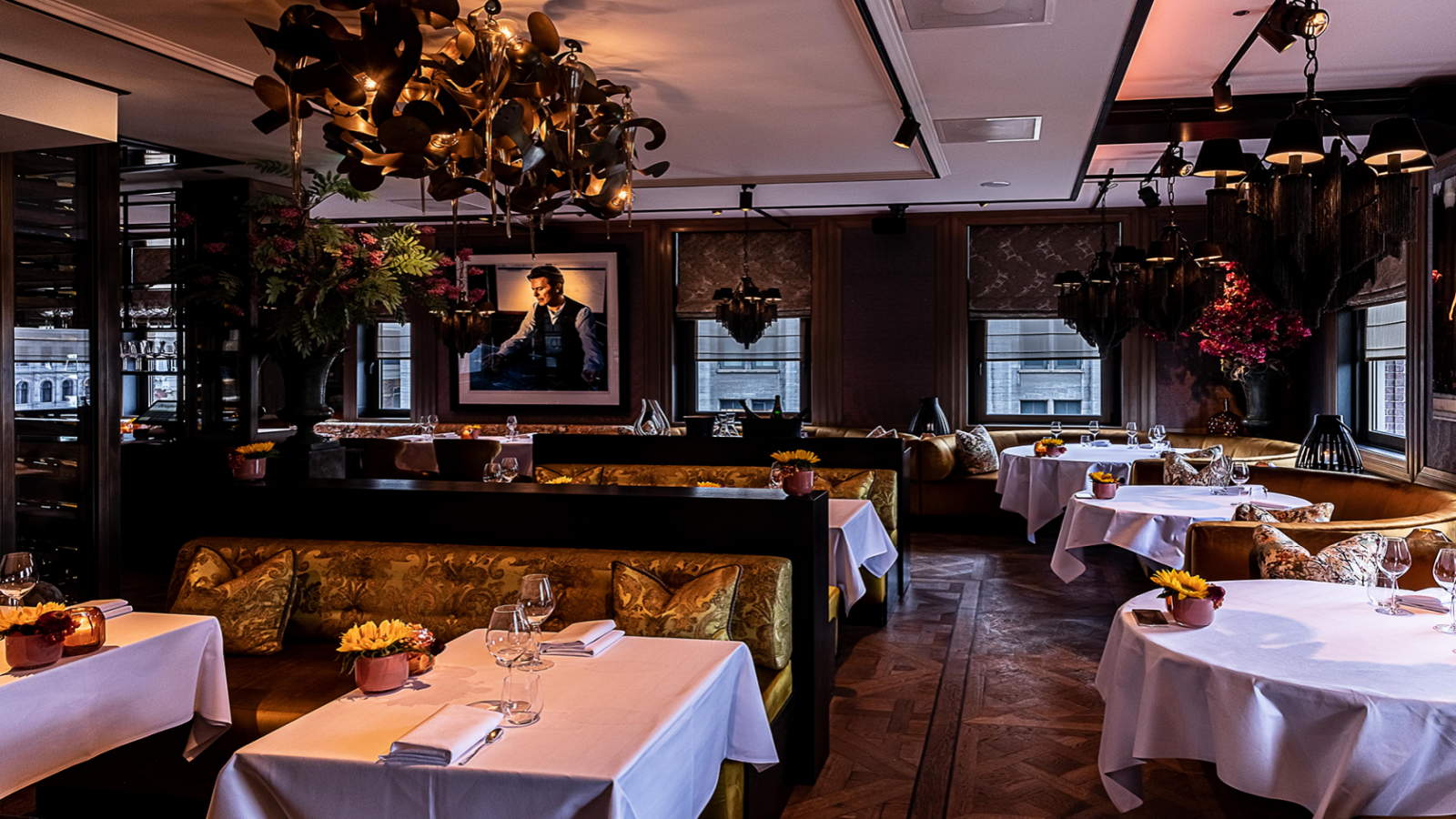 Chique restaurantinterieur restaurant Bougainville met gedekte tafels, sierlijke decoraties en een groot ingelijst portret.