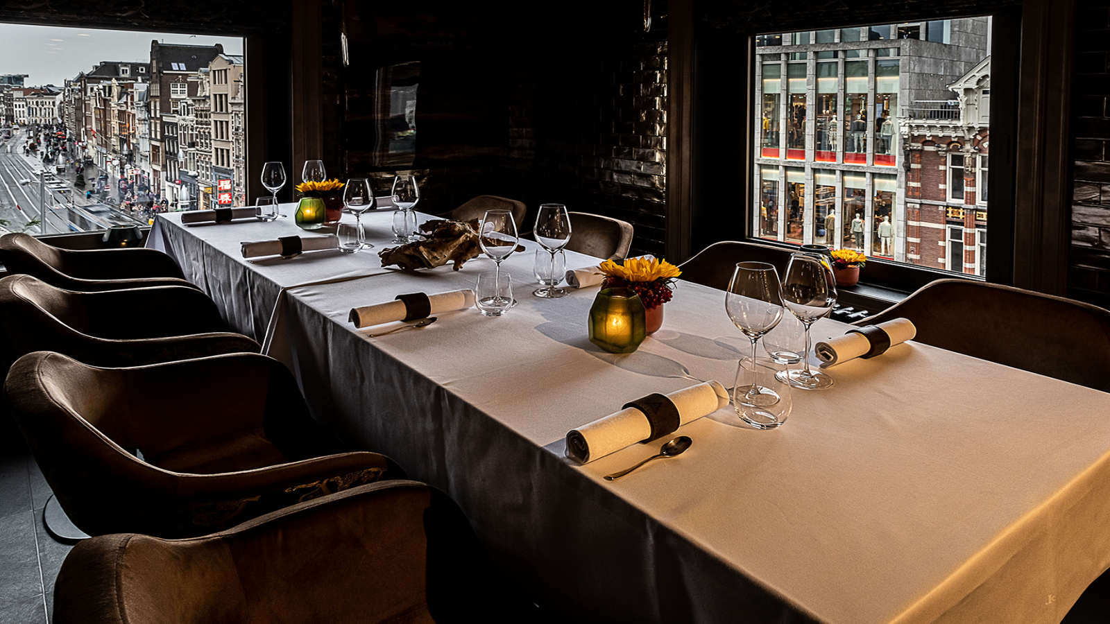 Formeel gedekte eettafel Chef's Table voor een maaltijd met uitzicht op de stad vanuit de ramen.