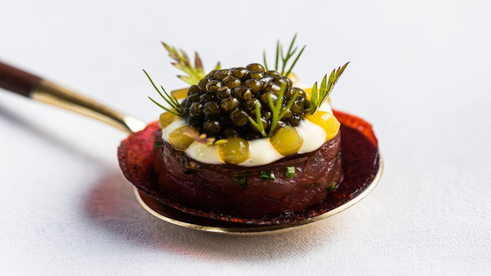 Restaurant Bougainville: Klein voorgerechtje op een gouden lepel: donkere kaviaar, dilletakjes op een bruine, ronde bodem.