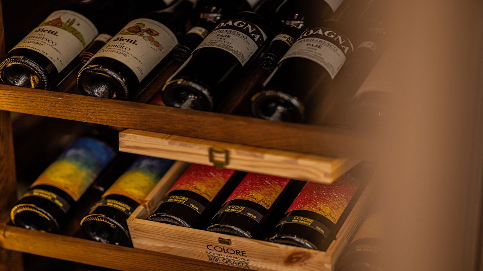 Wijnflessen in een houten rek. Sommige flessen staan ​​in een houten kist.