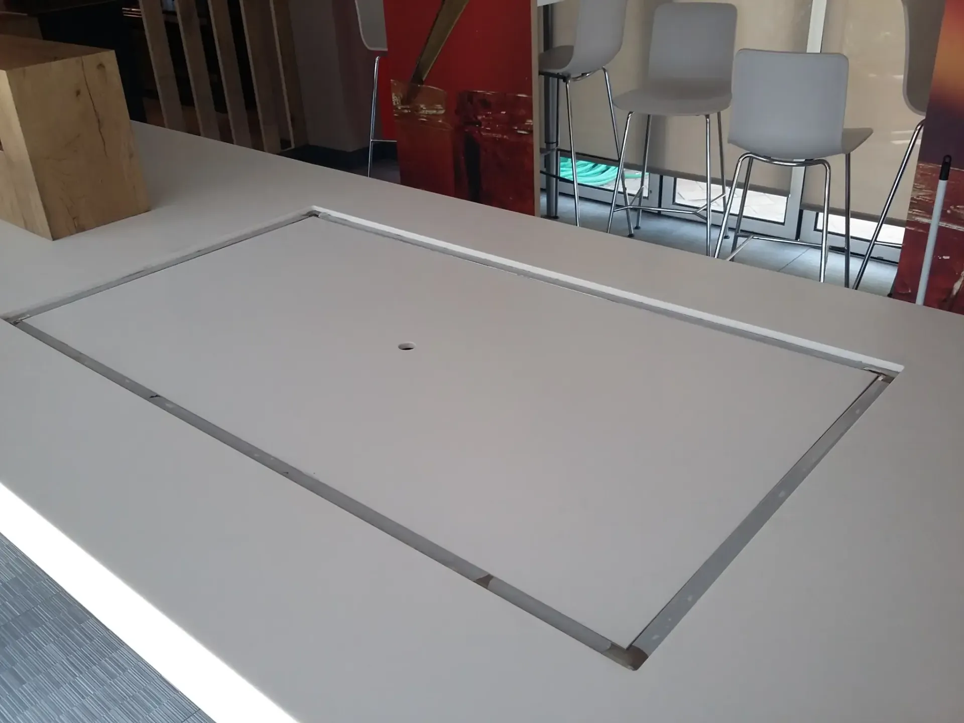 Mesa rectangular de color blanco con un hueco en el centro y un pequeño agujero.