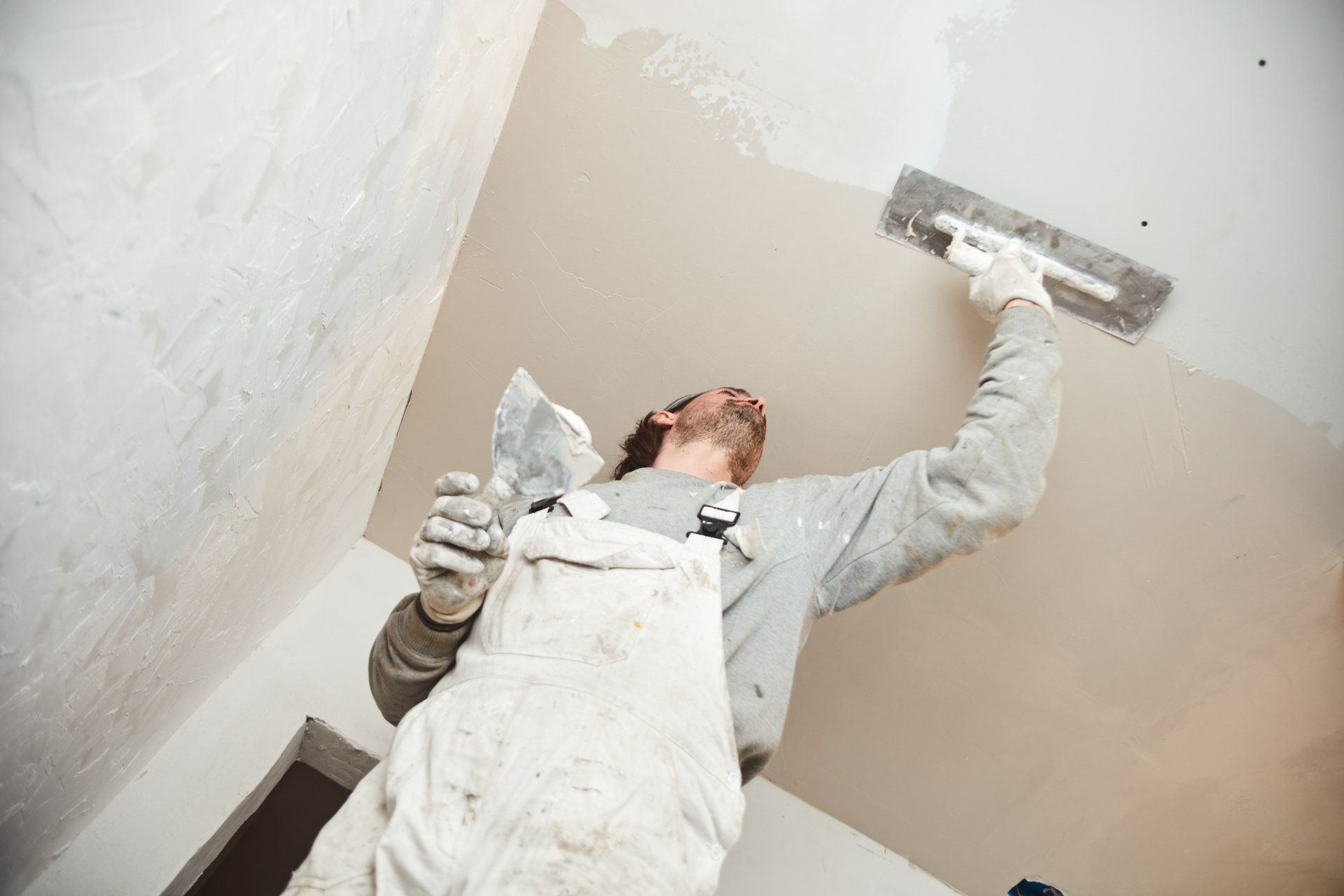 Homme qui met du plâtre sur un plafond