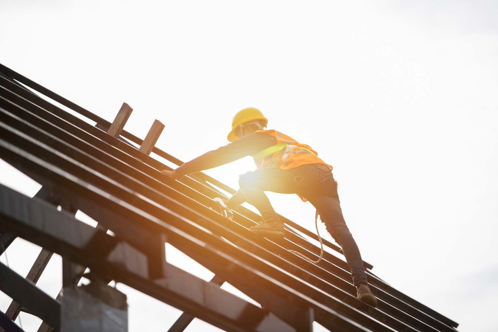 Couvreur sur un toit qui pose une charpente