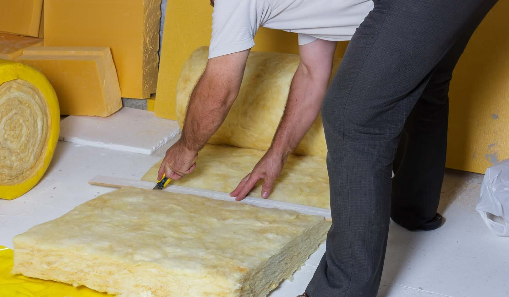 Homme qui coupe des plaques en mousse pour l'isolation intérieure
