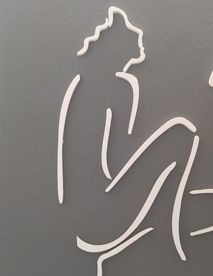 Contorno blanco de una persona sentada con cabello rizado sobre un fondo gris.