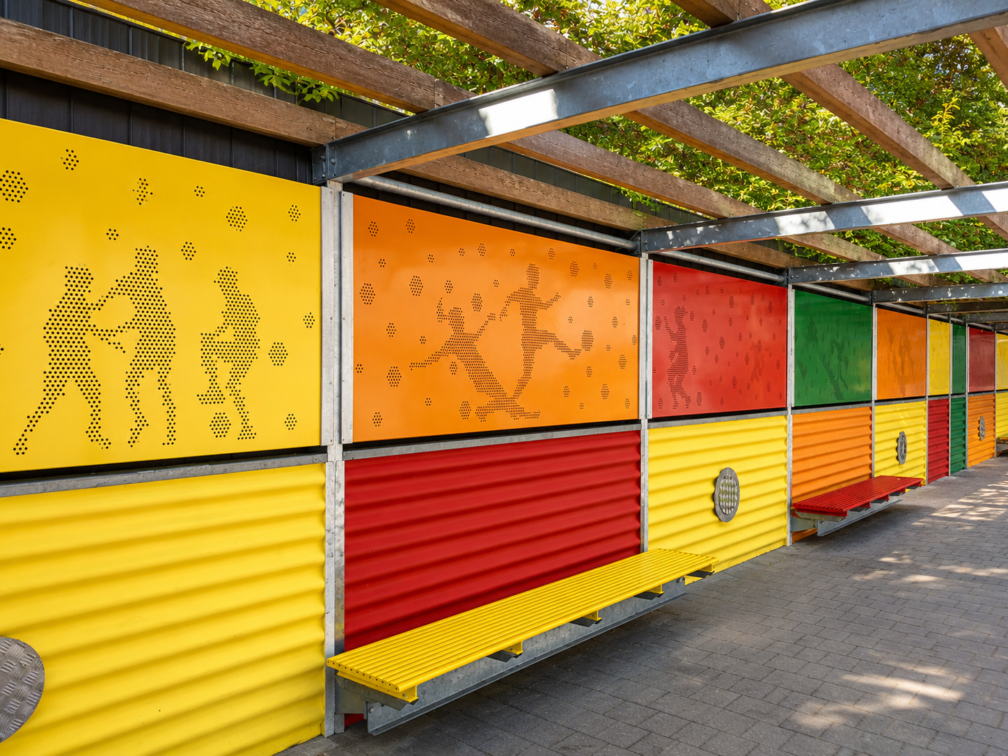 Bunte Sitzbänke im Freien mit orangefarbenen, gelben, roten und grünen Paneelen neben einem Gebäude