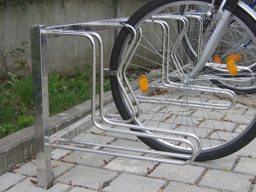 Außenrampe mit grauem Geländer und Betonfläche neben einem Haus und einem Gartenzaun