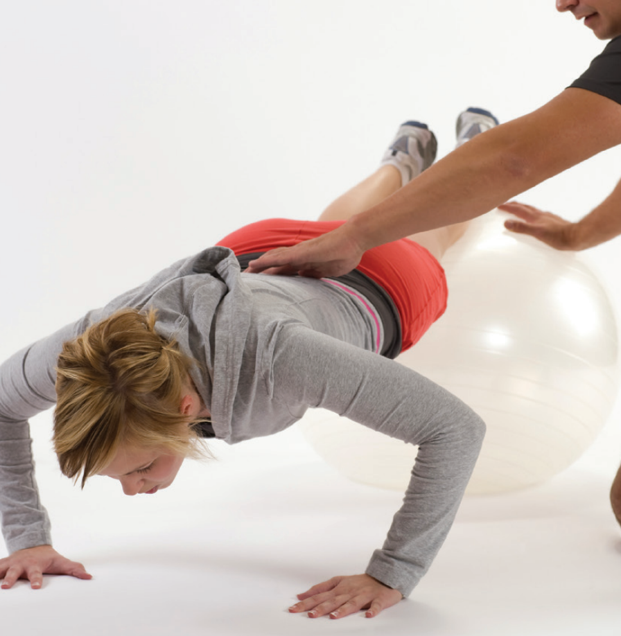 Une femme faisant des exercices accompagnés d'un coach