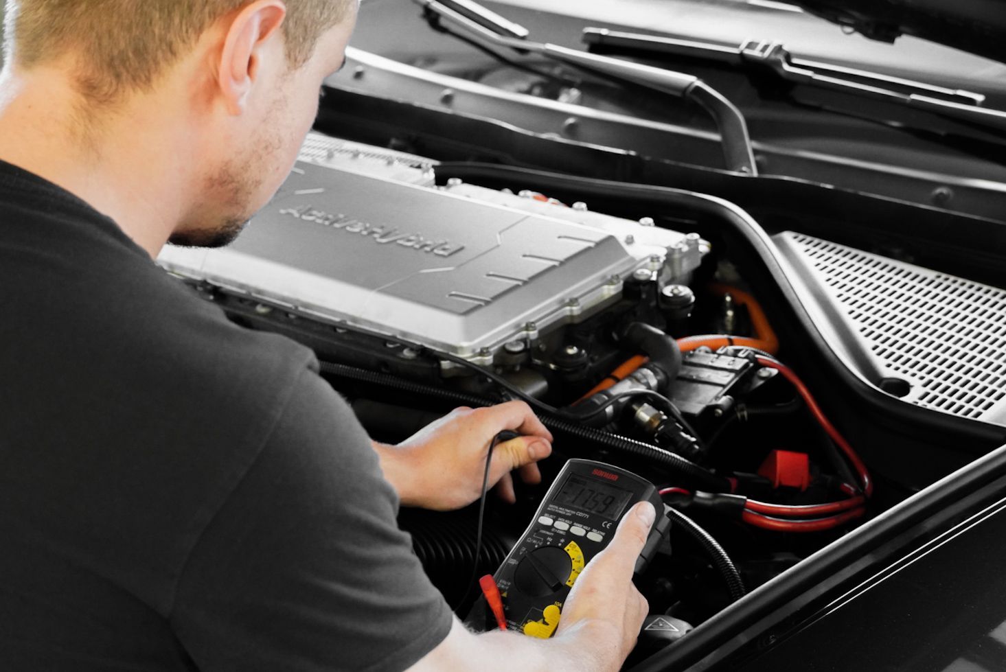 One Car AG - Mann mit Lackierpistole grundiert ein Karosserieteil