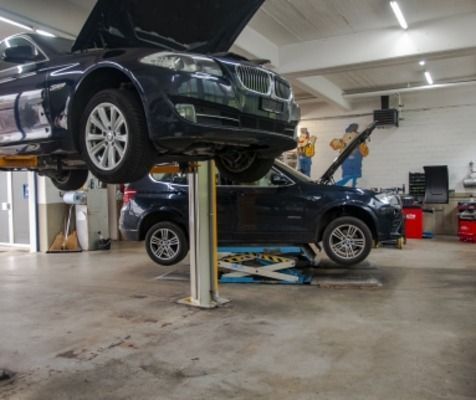 One Car AG - One Car AG - Zwei Fahrzeuge auf Hebebühnen in einer Autowerkstatt