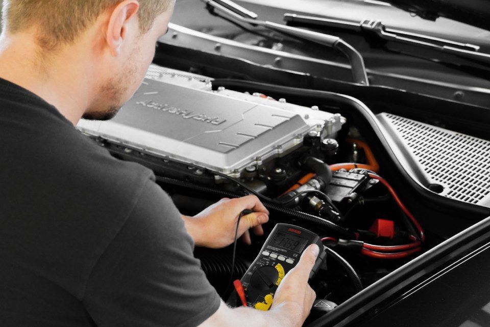 One Car AG - Mechaniker mit elektronischem Prüfgerät überprüft einen Motor